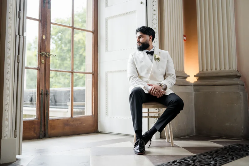 Ajay seated by a tall window
