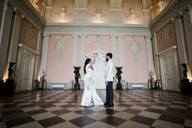A wide view of the couple beneath the chandelier