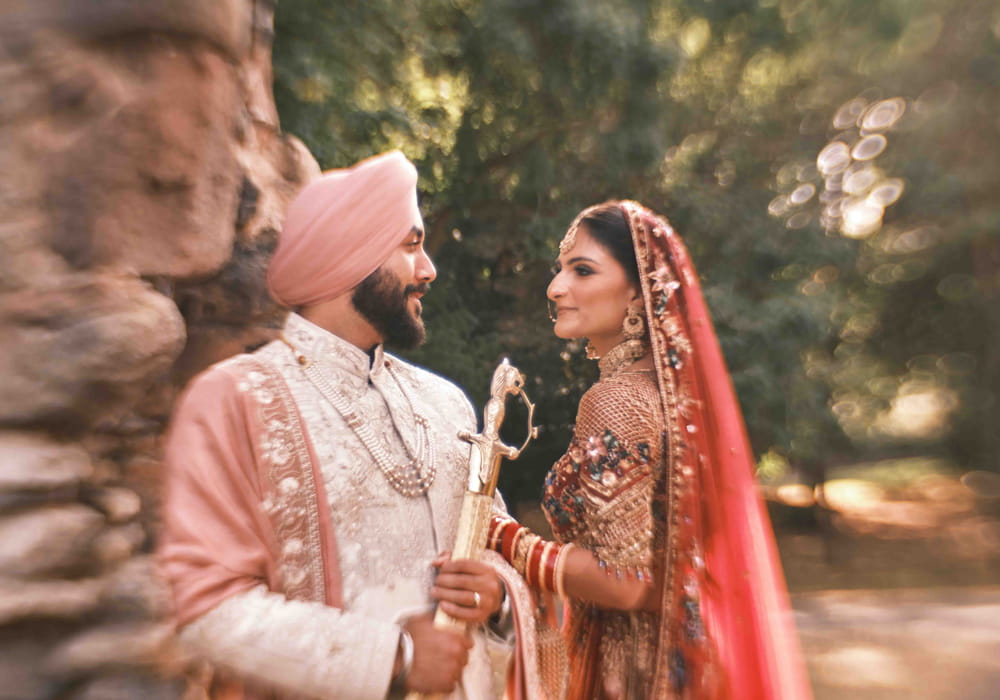 Bride and groom sharing a quiet moment beside a stone wall